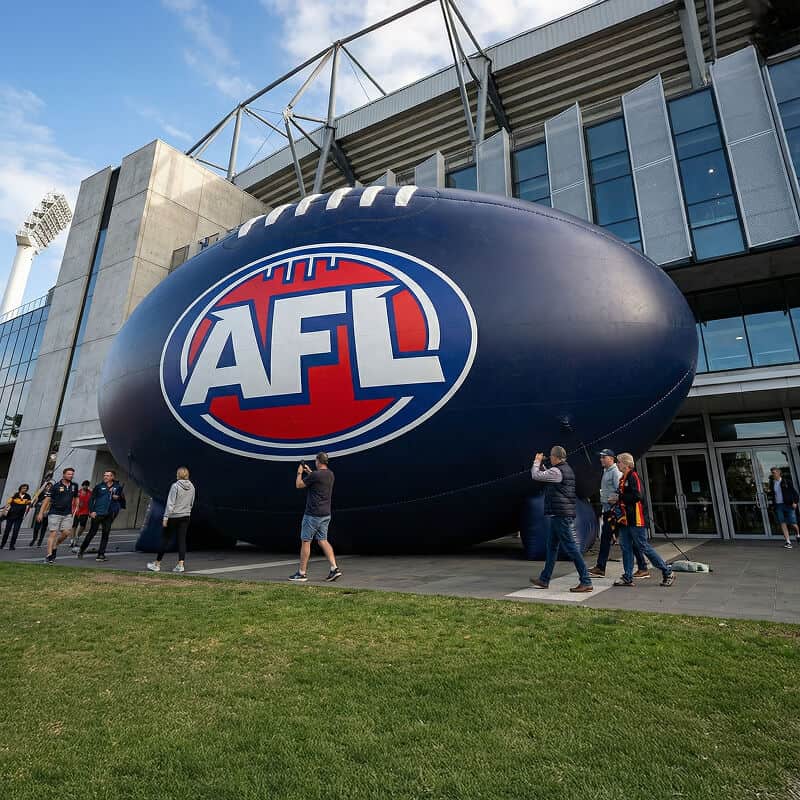 People walking past giant inflatable football