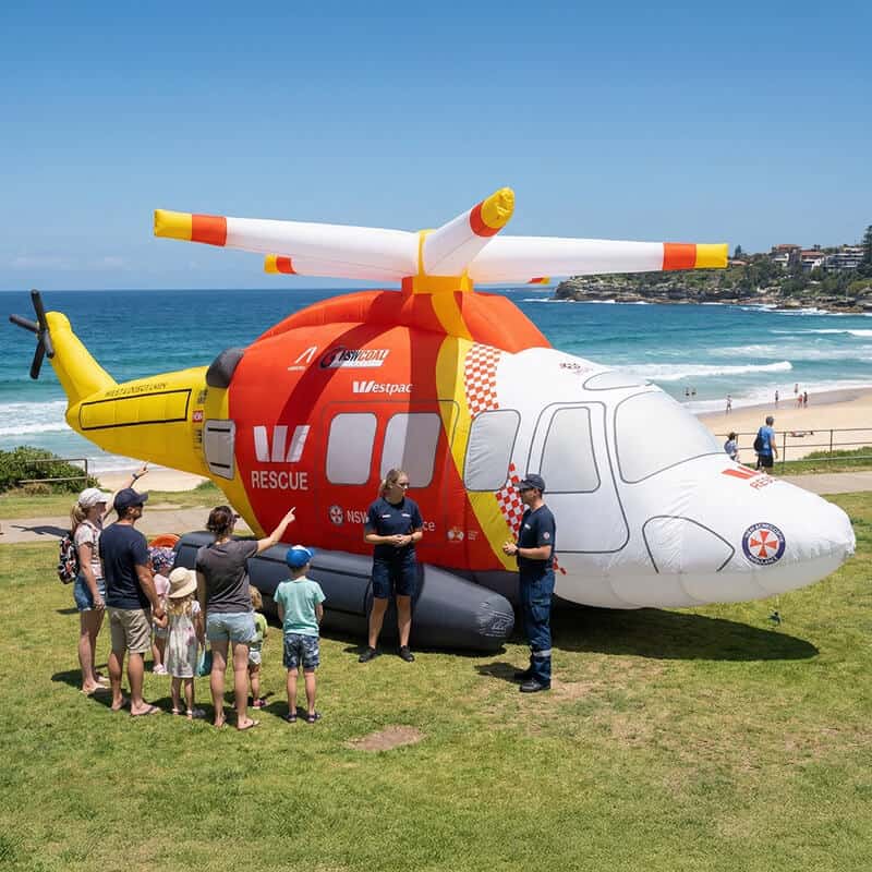 Kids looking at inflatable Westpac helicopter at beach